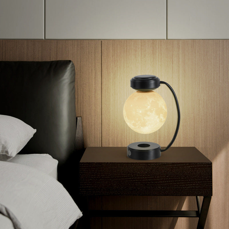 3D LED Moon Night Light Wireless Magnetic Levitating Rotatin on bedside table, creating a warm ambient glow.